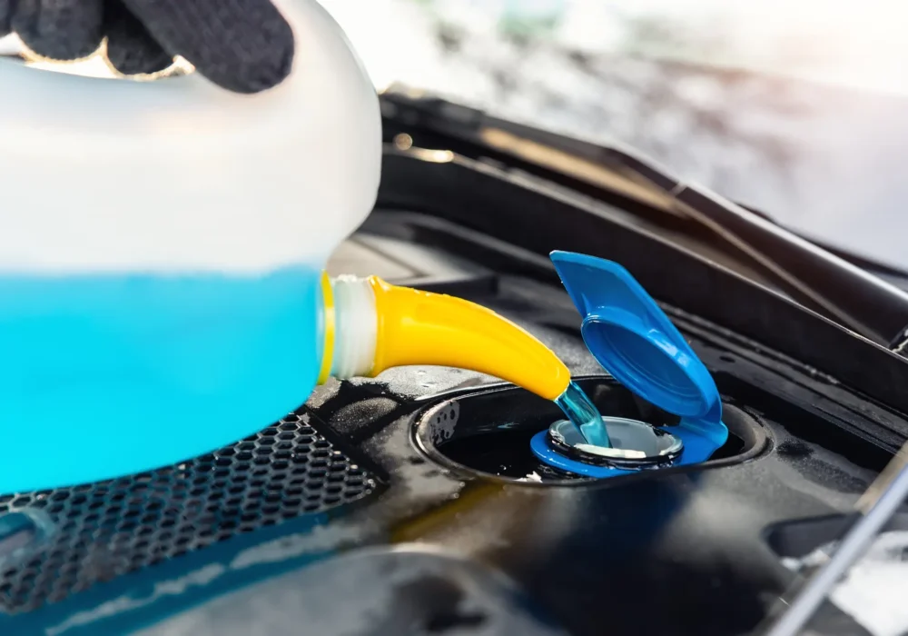 driver-hand-in-gloves-pouring-blue-antifreeze-li-2023-11-27-05-37-17-utc