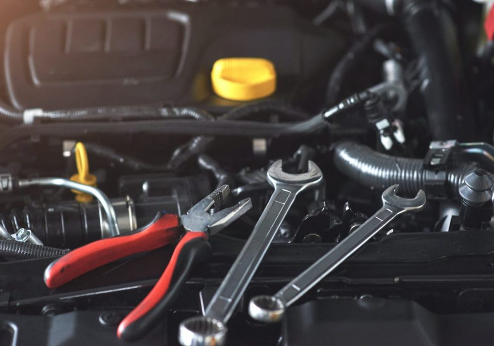 mechanic-hand-checking-and-fixing-a-broken-car-in-car-service-garage.jpg